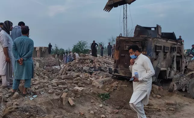 Police officers and local residents examine the site of overnight suicide bombing at a security post in Fatah Khel, in Bannu, a district in Pakistan's Khyber Pakhtunkhwa province bordering Afghanistan, Sunday, May 10, 2026. (AP Photo/Aamad Khattak)