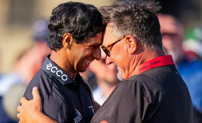 Aaron Rai, of England, left, hugs Justin Rose's caddie Mark Fulcher after finishing on the 18th green during the final round of the PGA Championship golf tournament at Aronimink Golf Club, Sunday, May 17, 2026, in Newtown Square, PA. (AP Photo/Frank Franklin II)