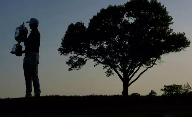 Aaron Rai, of England, holds the Wanamaker Trophy after winning the PGA Championship golf tournament at Aronimink Golf Club, Sunday, May 17, 2026, in Newtown Square, PA. (AP Photo/Carolyn Kaster)