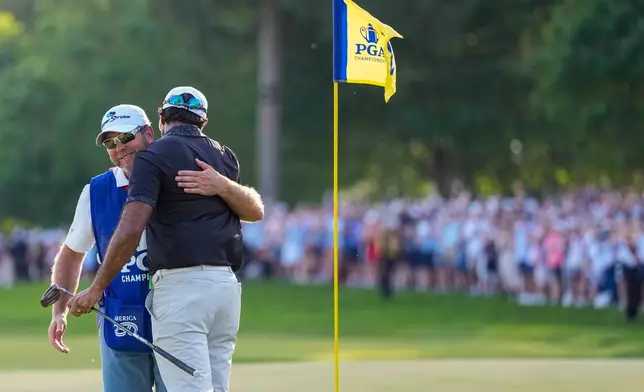 Aaron Rai, of England, embraces his caddie after his round on the 18th green during the final round of the PGA Championship golf tournament at Aronimink Golf Club, Sunday, May 17, 2026, in Newtown Square, PA. (AP Photo/Matt Slocum)