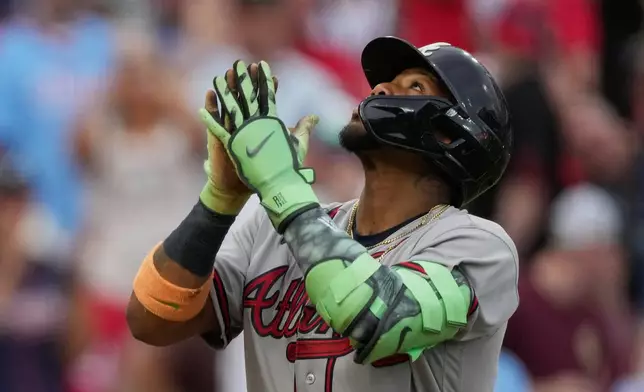 Atlanta Braves right fielder Ronald Acuña Jr. reacts as he crosses home plate after hitting a solo home run during the third inning of a baseball game against the Cincinnati Reds in Cincinnati, Saturday, May 30, 2026. (AP Photo/Carolyn Kaster)
