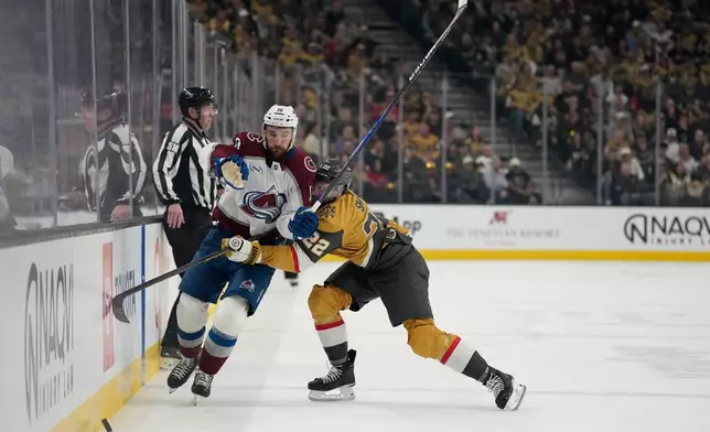Colorado Avalanche center Nicolas Roy (10) and Vegas Golden Knights right wing Cole Smith (22) battle for the puck during the first period in Game 4 of the Western Conference finals NHL hockey Stanley Cup playoff series Tuesday, May 26, 2026, in Las Vegas. (AP Photo/John Locher)