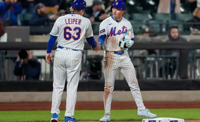New York Mets' A.J. Ewing (9) celebrates with a teammate after hitting an RBI triple during the seventh inning of a baseball game against the Detroit Tigers, Tuesday, May 12, 2026, in New York. (AP Photo/Yuki Iwamura)