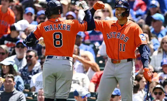 Houston Astros' Christian Walker (8) celebrates with teammate Cam Smith (11) after hitting a two-run home run during the first inning of a baseball game against the Chicago Cubs in Chicago, Saturday, May 23, 2026. (AP Photo/Paul Beaty)