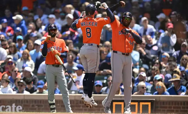 Houston Astros' Christian Walker (8) celebrates with Yordan Alvarez (44) after hitting a two-run home run during the first inning of a baseball game against the Chicago Cubs in Chicago, Saturday, May 23, 2026. (AP Photo/Paul Beaty)