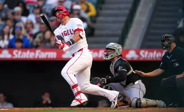 Los Angeles Angels' Mike Trout, left, heads to first for a solo home run as Chicago White Sox catcher Edgar Quero, center, and home plate umpire Jansen Visconti watch during the first inning of a baseball game Tuesday, May 5, 2026, in Anaheim, Calif. (AP Photo/Mark J. Terrill)