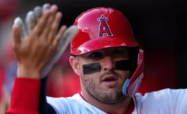 Los Angeles Angels' Mike Trout is congratulated by teammates in the dugout after hitting a solo home run during the first inning of a baseball game against the Chicago White Sox, Tuesday, May 5, 2026, in Anaheim, Calif. (AP Photo/Mark J. Terrill)