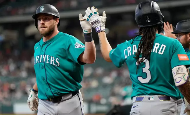 Seattle Mariners' Luke Raley, left, celebrates with J.P. Crawford after hitting a home run during the first inning of a baseball game against the Houston Astros in Houston, Thursday, May 14, 2026. (AP Photo/Ashley Landis)