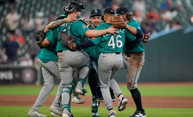Seattle Mariners players celebrate after winning a baseball game against the Houston Astros in Houston, Thursday, May 14, 2026. (AP Photo/Ashley Landis)