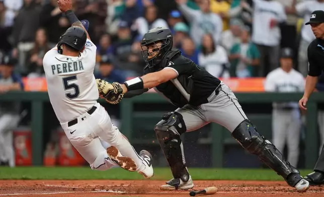 Chicago White Sox catcher Drew Romo tags out Seattle Mariners' Jhonny Pereda at home on a double from Randy Arozarena, but is counted as a run scored after a review determined second baseman Sam Antonacci committed interference on the base path during the third inning of a baseball game, Monday, May 18, 2026, in Seattle. (AP Photo/Lindsey Wasson)