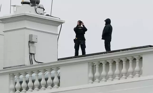 U.S. Secret Service Police observe from the roof of the White House, Saturday, May 23, 2026, in Washington, after reports of shots fired near the White House. (AP Photo/Jose Luis Magana)