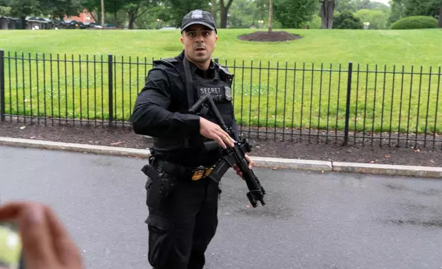 A member of the Secret Service stops journalist from leaving the White House, Saturday, May 23, 2026, in Washington. (AP Photo/Jose Luis Magana)