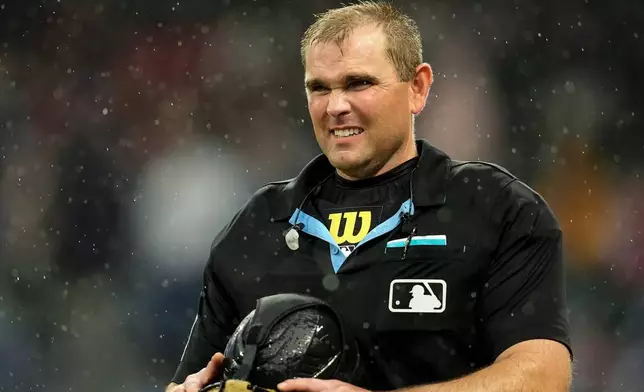 An MLB umpire leaves the game due to rain in the sixth inning of a baseball game between the Atlanta Braves and the Washington Nationals, Sunday, May 24, 2026, in Atlanta. (AP Photo/Mike Stewart)