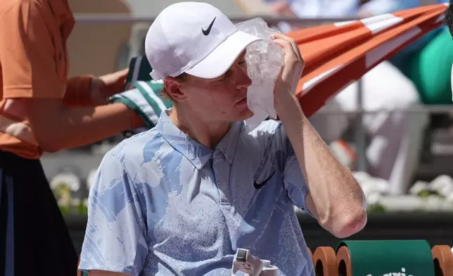 Jannik Sinner of Italy cools himself with the ice during the second round men's singles tennis match against Juan Manuel Cerundolo of Argentina at the French Open tennis tournament in Paris, Thursday, May 28, 2026. (AP Photo/Thibault Camus)