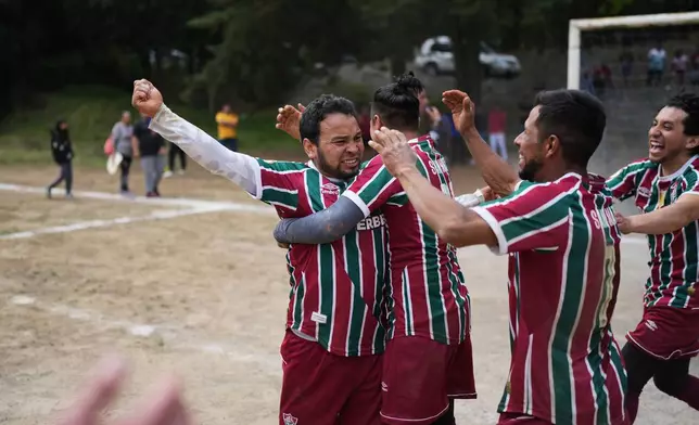San Mateo soccer club players celebrate the penalty shot by Jesus Flores, left, that gave them the victory over Tepetlapa at the end of a tournament final on a soccer field nestled inside the crater of the extinct Teoca Volcano in the town of Santa Cecilia Tepetlapa in the Xochimilco borough of Mexico City, Sunday, April 26, 2026. (AP Photo/Eduardo Verdugo)