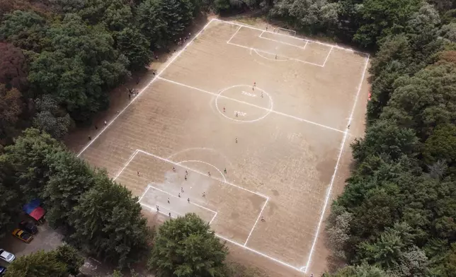 A soccer field nestled inside the crater of the extinct Teoca volcano hosts a local tournament match in the town of Santa Cecilia Tepetlapa in the Xochimilco borough of Mexico City, Sunday, April 19, 2026. (AP Photo/Eduardo Verdugo)