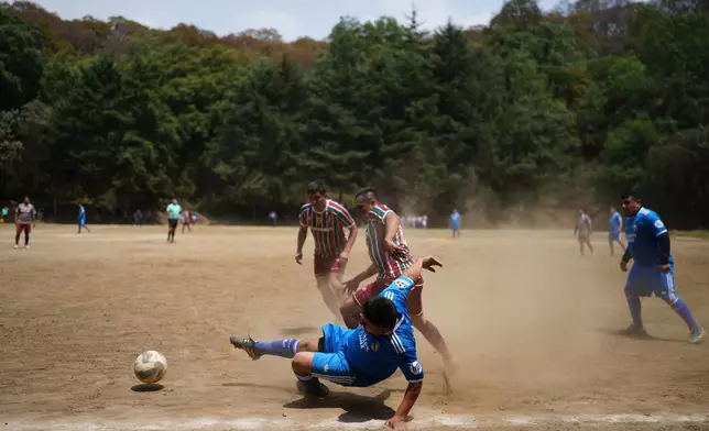 A soccer field nestled inside the crater of the extinct Teoca volcano hosts a local tournament match in the town of Santa Cecilia Tepetlapa in the Xochimilco borough of Mexico City, Sunday, April 19, 2026. (AP Photo/Eduardo Verdugo)