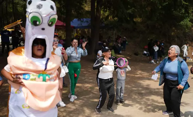 Fans cheer on the sidelines of the final tournament game between San Mateo and Tepetlapa clubs on a soccer field inside the crater of the extinct Teoca Volcano in the town of Santa Cecilia Tepetlapa in the Xochimilco borough of Mexico City, Sunday, April 26, 2026. (AP Photo/Eduardo Verdugo)
