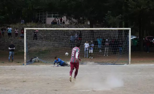 A San Mateo player scores a penalty shot past the Tepetlapa goal keeper during a match on a soccer field inside the crater of the extinct Teoca Volcano in the town of Santa Cecilia Tepetlapa in the Xochimilco borough of Mexico City, Sunday, April 26, 2026. (AP Photo/Eduardo Verdugo)