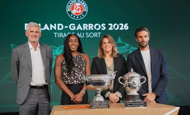 French tennis federation President Gilles Moretton, from left, United States' Coco Gauff, Roland-Garros tournament director Amelie Mauresmo and IOC member Tony Estanguet pose next to the trophies during the draw of French Open tennis tournament, Thursday, May 21, 2026, at the Roland Garros stadium in Paris. (AP Photo/Thibault Camus)