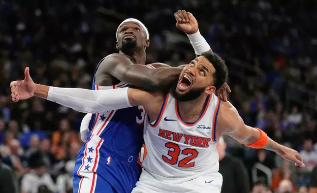 Philadelphia 76ers' Adem Bona, top, fouls New York Knicks' Karl-Anthony Towns during the second half of Game 1 in a second-round NBA basketball playoffs series Monday, May 4, 2026, in New York. (AP Photo/Seth Wenig)