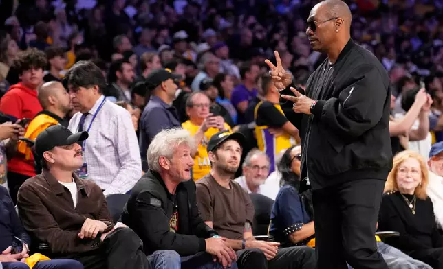 Actor Eddie Murphy, right, gestures as he walks off the court while actor Leonardo DiCaprio, left, and Sean Penn, second from left, watch during the second half of Game 4 in a second-round NBA basketball playoffs series between the Los Angeles Lakers and the Oklahoma City Thunder, Monday, May 11, 2026, in Los Angeles. (AP Photo/Mark J. Terrill)