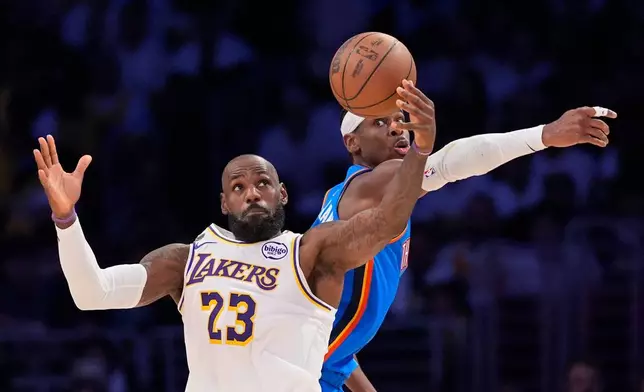 Los Angeles Lakers forward LeBron James, left, takes a pass as Oklahoma City Thunder guard Shai Gilgeous-Alexander defends during the first half of Game 3 in a second-round NBA basketball playoffs series Saturday, May 9, 2026, in Los Angeles. (AP Photo/Mark J. Terrill)