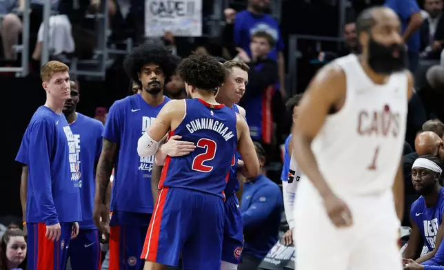 Detroit Pistons guard Cade Cunningham (2) is hugged by Duncan Robinson as Kevin Huerter, left, and Tolu Smith wait late in the fourth quarter of a loss to the Cleveland Cavaliers during Game 7 in a second-round NBA basketball playoffs series Sunday, May 17, 2026, in Detroit. (AP Photo/Duane Burleson)