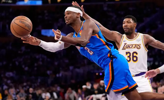 Oklahoma City Thunder guard Shai Gilgeous-Alexander, left, passes as Los Angeles Lakers guard Marcus Smart defends during the second half of Game 3 in a second-round NBA basketball playoffs series Saturday, May 9, 2026, in Los Angeles. (AP Photo/Mark J. Terrill)