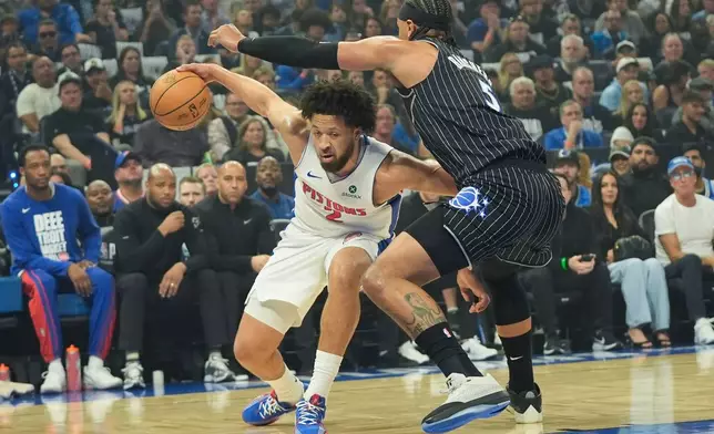 Detroit Pistons guard Cade Cunningham, left, tires to get past Orlando Magic forward Paolo Banchero, right, during the first half in Game 6 of a first-round NBA basketball playoffs series, Friday, May 1, 2026, in Orlando, Fla. (AP Photo/John Raoux)