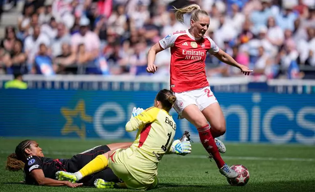 Lyonnes' Wendie Renard, left, gets to the ball ahead of Arsenal's Stina Blackstenius, right, during the Women's Champions League semifinal, second leg, soccer match between OL Lyonnes and Arsenal, in Decines, outside Lyon, France, Saturday, May 2, 2026. (AP Photo/Laurent Cipriani)