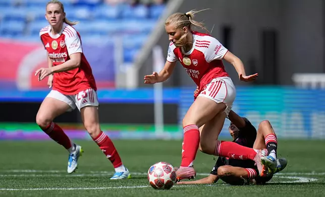 Arsenal's Smilla Holmberg and Alessia Russo, left, drive the ball past Lyonnes' Selma Bacha, eon the ground, during the Women's Champions League semifinal, second leg, soccer match between OL Lyonnes and Arsenal, in Decines, outside Lyon, France, Saturday, May 2, 2026. (AP Photo/Laurent Cipriani)