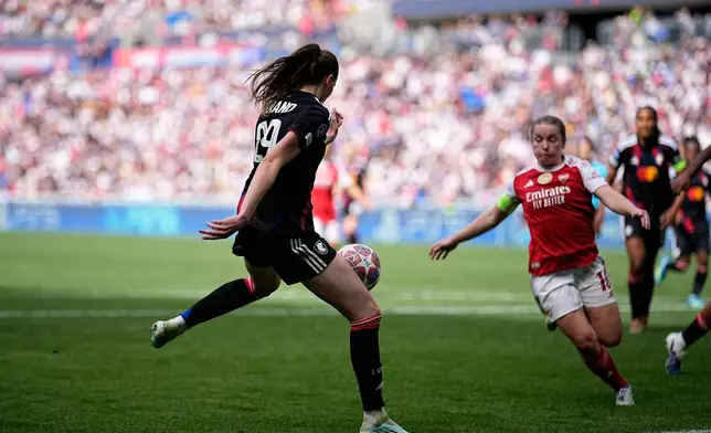 Lyonnes' Jule Brand, left, scores her side's third goal during the Women's Champions League semifinal, second leg, soccer match between OL Lyonnes and Arsenal, in Decines, outside Lyon, France, Saturday, May 2, 2026. (AP Photo/Laurent Cipriani)