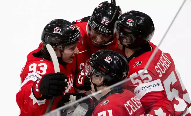 Canada's Mark Scheifele, right celebrates the winning goal in overtime with teammates, during the 2026 IIHF Men's Ice Hockey World Championship preliminary round group B game between Canada and Norway, in Fribourg, Switzerland, Thursday, May 21, 2026. (Anthony Anex/Keystone via AP)