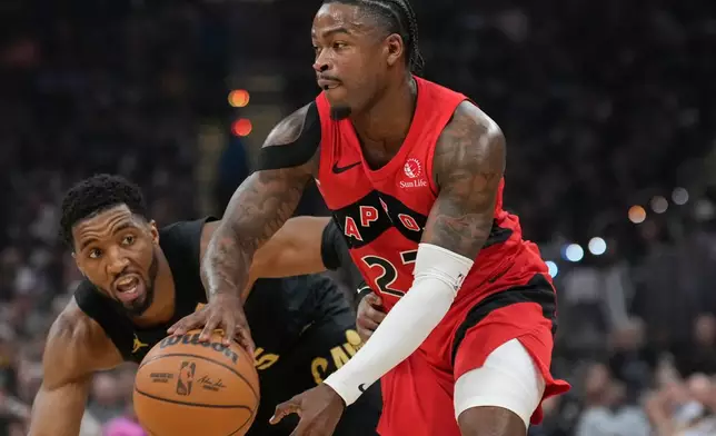 Toronto Raptors guard Jamal Shead (23) drives past Cleveland Cavaliers guard Donovan Mitchell, left, in the first half in Game 7 of a first-round NBA basketball playoffs series in Cleveland, Sunday, May 3, 2026. (AP Photo/Sue Ogrocki)