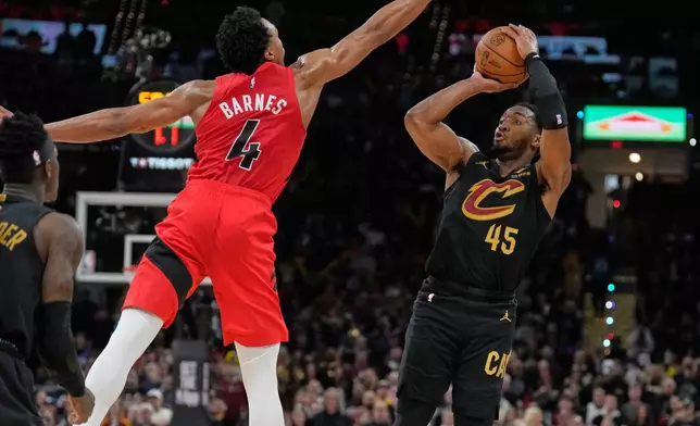 Cleveland Cavaliers guard Donovan Mitchell (45) shoots as Toronto Raptors forward Scottie Barnes (4) defends in the second half in Game 7 of a first-round NBA basketball playoffs series in Cleveland, Sunday, May 3, 2026. (AP Photo/Sue Ogrocki)