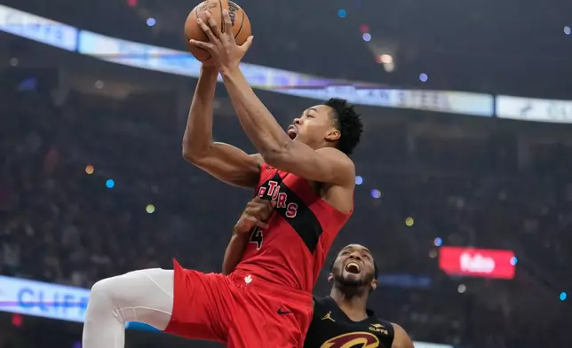 Toronto Raptors forward Scottie Barnes (4) is fouled by Cleveland Cavaliers guard Donovan Mitchell, right, in the first half in Game 7 of a first-round NBA basketball playoffs series in Cleveland, Sunday, May 3, 2026. (AP Photo/Sue Ogrocki)