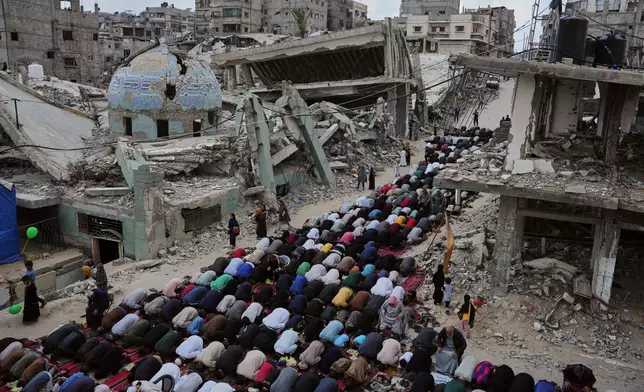 Palestinians offer Eid al-Adha prayers beside the ruins of a mosque destroyed by Israeli bombardment, in Khan Younis, southern Gaza Strip, Wednesday, May 27, 2026. (AP Photo/Abdel Kareem Hana)