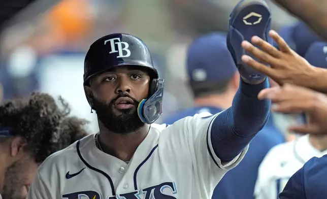 Tampa Bay Rays' Junior Caminero celebrates with teammates after scoring on an RBI triple by Ryan Vilade off Baltimore Orioles pitcher Trevor Rogers during the fourth inning of a baseball game Monday, May 18, 2026, in St. Petersburg, Fla. (AP Photo/Chris O'Meara)