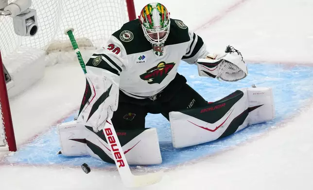 Minnesota Wild goaltender Jesper Wallstedt makes a stick-save in the first period of Game 1 of an NHL hockey Stanley Cup second-round playoff series against the Colorado Avalanche, Sunday, May 3, 2026, in Denver. (AP Photo/David Zalubowski)