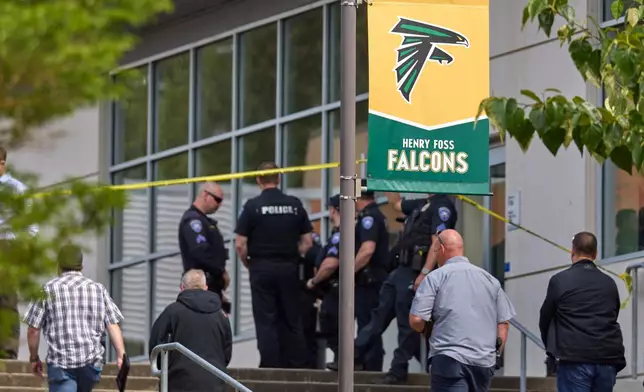 Tacoma Police officers investigate after multiple people were injured in a stabbing at Foss High School, Thursday, April 30, 2026, in Tacoma, Wash. (AP Photo/John Froschauer)