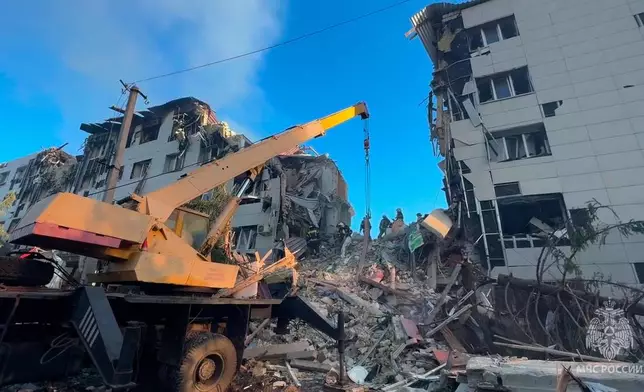 In this image taken from video released by Russian Emergency Ministry Press Service Telegram channel on Friday, May 22, 2026, Rescuers work at the side of a college dormitory building damaged by Ukrainian drones in Starobilsk, Ukraine. (Russian Emergency Ministry Press Service via AP)