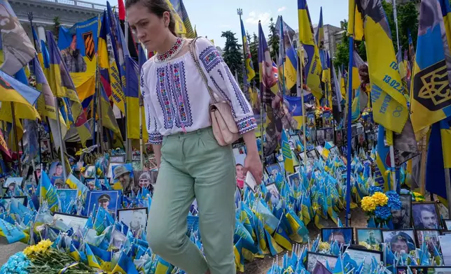 A woman looks at a makeshift memorial for fallen soldiers in Russia Ukraine war on Independence Square in Kyiv, Ukraine, Friday, May 22, 2026. (AP Photo/Efrem Lukatsky)