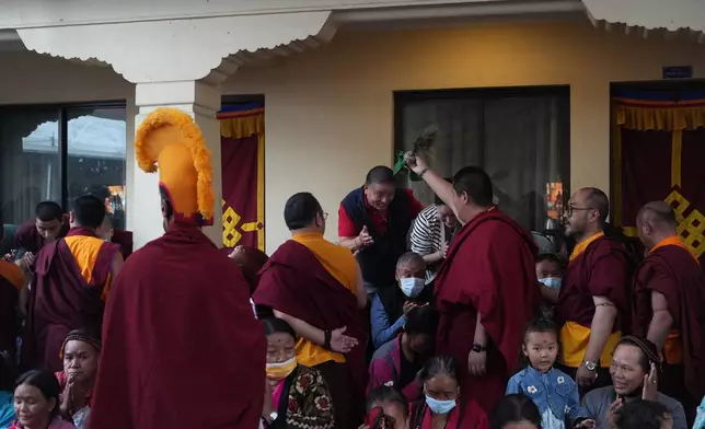 U.S.-born Buddhist lama Jalue Dorje blesses his father, Dorje Tsegyal, and mother, Dechen Wangmo, at the end of 12 days of empowerments, or initiation rituals and teachings, bestowed by the abbot of Shechen Monastery in Kathmandu, Nepal, on Sunday, April 12, 2026. (AP Photo/Luis Andres Henao)