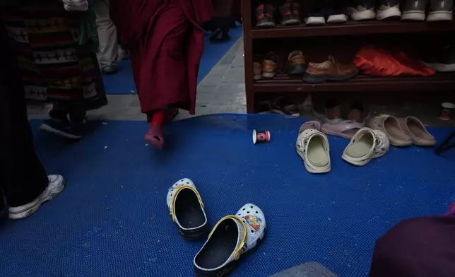 Crocs decorated with Jibbitz charms of The Simpsons, belonging to U.S.-born Buddhist lama Jalue Dorje, sit outside a prayer hall at Shechen Monastery in Kathmandu, Nepal, on Sunday, April 12, 2026. (AP Photo/Luis Andres Henao)