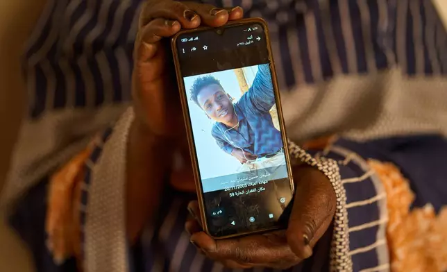Sulafa Mustafa shows a photograph of her missing son, Suleiman Abdelsaid, in Omdurman, Sudan, Tuesday, April 21, 2026. (AP Photo/Bernat Armangue)