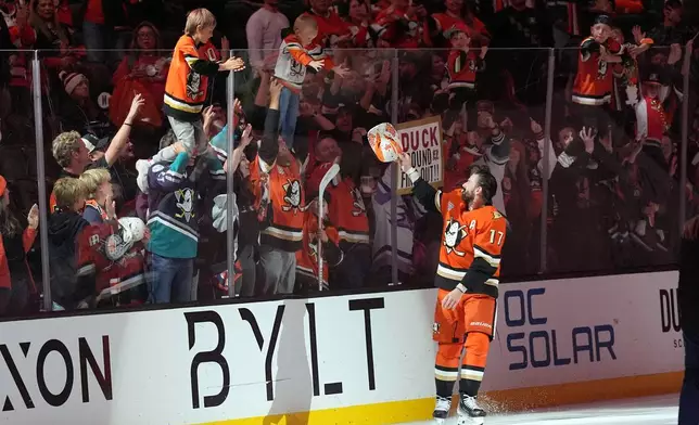 Number one star of the game Anaheim Ducks' Alex Killorn (17) hands an autographed souvenir to a young fan after their win over the Vegas Golden Knights after the third period of Game 4 of an NHL hockey series Sunday, May 10, 2026, in Anaheim, Calif. (AP Photo/Scott Strazzante)