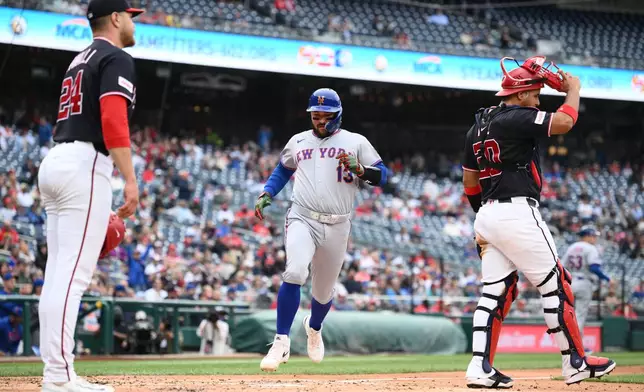 New York Mets' Luis Torrens (13) comes in to score on a single by Bo Bichette during the third inning of a baseball game next to Washington Nationals pitcher Cade Cavalli (24) and catcher Keibert Ruiz (20), Thursday, May 21, 2026, in Washington. (AP Photo/Nick Wass)