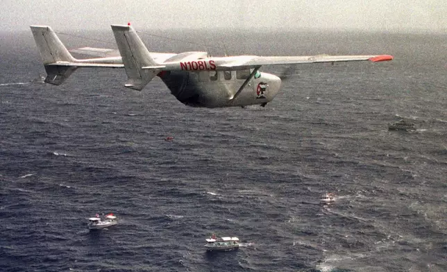 FILE - A Brothers to the Rescue plane flies over The Democracy Movement flotilla at the twelve-mile limit north of Havana, Cuba, July 10, 1999. (AP Photo/Alan Diaz, File)
