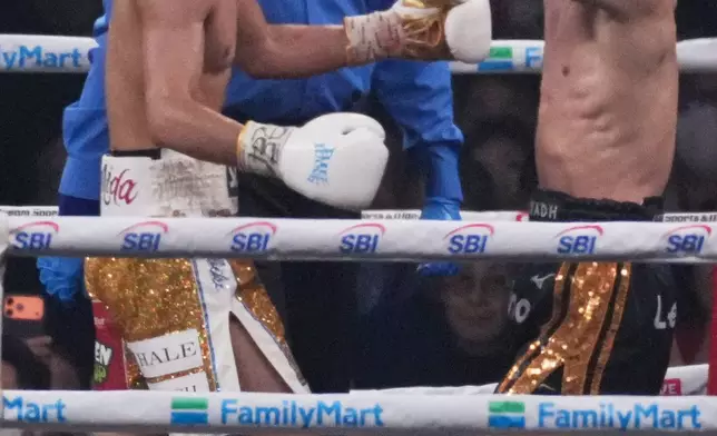 Naoya Inoue of Japan, right, celebrates as he beat Junto Nakatani of Japan in a boxing match for the WBA, WBC, IBF and WBO super bantamweight world title in Tokyo, Saturday, May 2, 2026. (AP Photo/Hiro Komae)